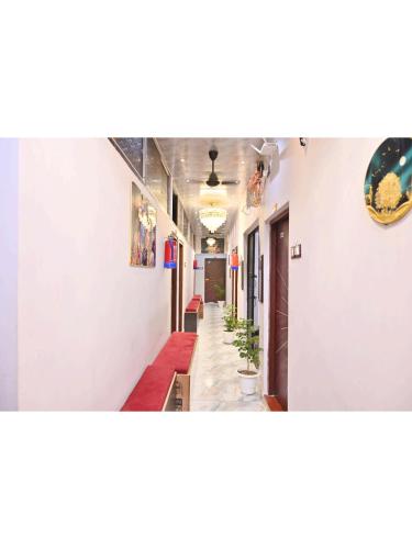 a hallway with white walls and a long hallway with plants at Kashi Dream Guest House in Varanasi