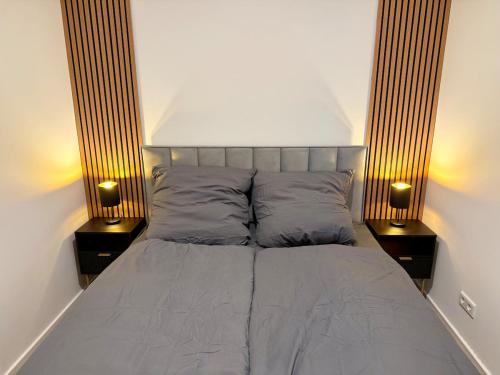 a bedroom with a bed with two lamps on it at Holiday Apartment in Osnabrück 12001 in Osnabrück