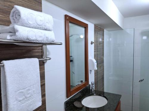 a bathroom with a sink and a mirror at Hotel CGH Travel INN Airport in Bogotá