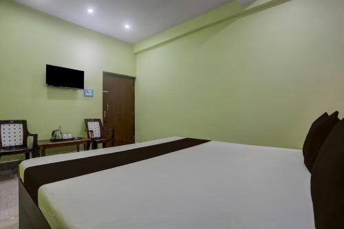 a bedroom with a bed and a tv on the wall at Hotel O SAI KRISHNA GUEST HOUSE in Kendrāparha