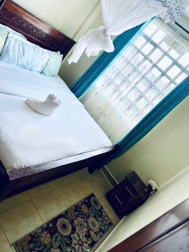 ein Schlafzimmer mit einem Bett und einem Fenster in der Unterkunft Nova suite in Eldoret