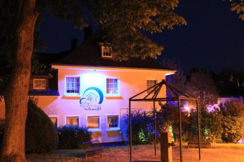 un edificio blanco con un cartel en él por la noche en Ferienwohnung Daun, en Daun