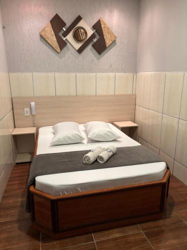 a bedroom with a bed with two slippers on it at Hotel Anoitecer - 100 metros metrô Carandiru, 700 metros Rodoviária do Tietê, 900 metros Aeroporto Campo de Marte, 1,4 km Expor center norte, 1,8 km Distrito do anhembi! Oferecemos como cortesia café da manhã e estacionamento! in São Paulo