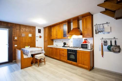 Una cocina con gabinetes de madera y un horno de estufa. en Casa Liscidini, en Aprica