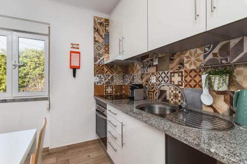 a kitchen with a sink and a counter top at Meco Garden Retreat - near Sesimbra in Alfarim