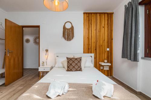 a bedroom with a white bed with two pillows on it at Casa das Laranjeiras in Alfarim