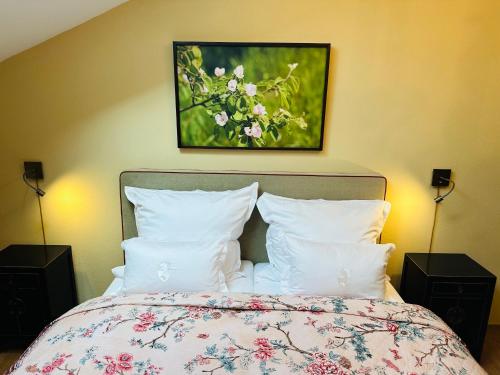 a bedroom with a bed with a painting on the wall at SEEBERGER GÜTL - by "Schloss Gessenberg" Exclusive apartments with a historic ambience for lovers of art and antiques in Petting
