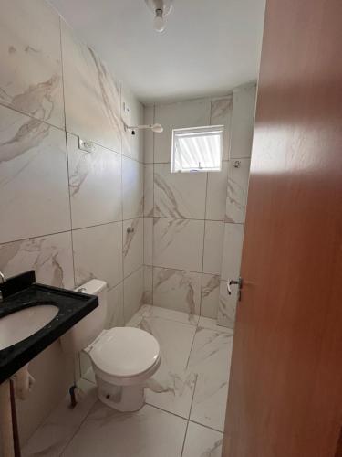 une salle de bains blanche avec toilettes et lavabo dans l'établissement Apartamento completo -João Pessoa 2 quartos -praia do sol, à João Pessoa