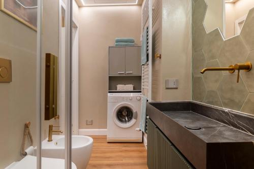 a bathroom with a washing machine and a washer and dryer at Claire de Lune in Asti