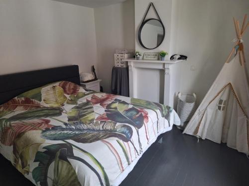 a bedroom with a bed with a colorful blanket at Sandrashuis in Zulte