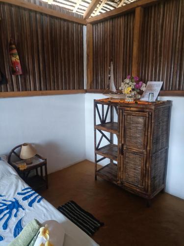 a room with a bed and a table with flowers on it at La Maison de Morgana in Ambaro