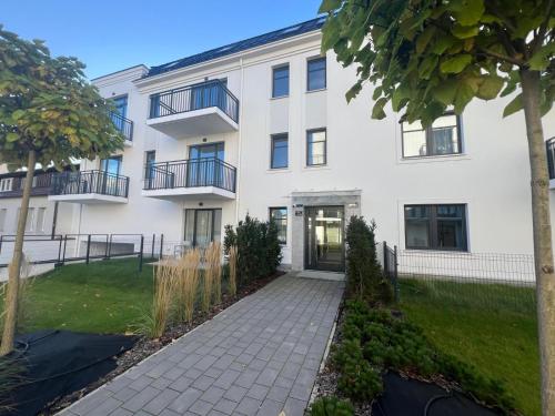 einen Blick nach außen auf ein weißes Gebäude in der Unterkunft Apartamenty Wilenska in Słupsk