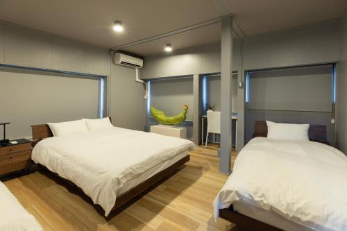 a bedroom with two beds and a mirror at 博多町家小箱 in Fukuoka