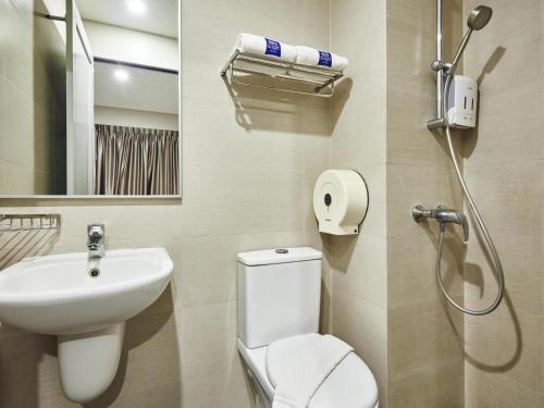 a bathroom with a toilet and a sink and a shower at ibis budget Singapore Clarke Quay in Singapore
