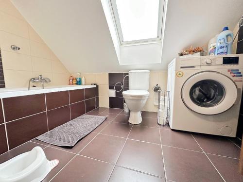 Un baño con lavadora y un inodoro. en Byt 3kk, en Frýdek-Místek