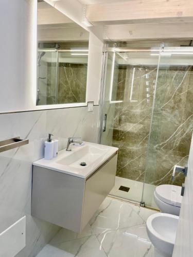 a white bathroom with a sink and a shower at Élite Lampedusa in Lampedusa
