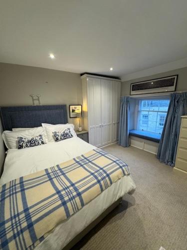 a bedroom with a large bed and a window at Vine House in Tetbury
