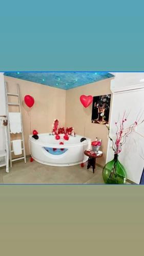 ein Badezimmer mit einer Badewanne mit roten Herzen und Luftballons in der Unterkunft Capri house in Fasano