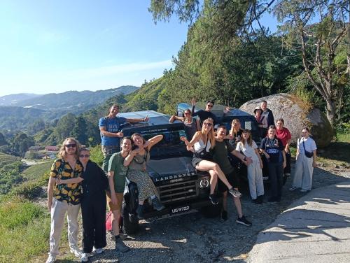 Un grupo de personas de pie alrededor de un coche en una carretera. en A3A Oastel CoLiving, en Tanah Rata