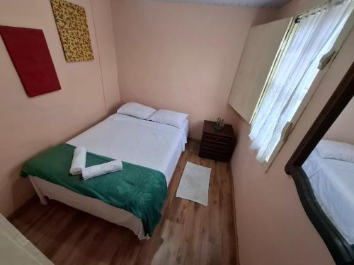 a small bedroom with a bed and a window at Aluguel temporada in Ouro Preto