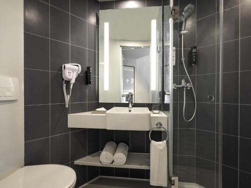 a bathroom with a sink and a toilet and a mirror at ibis Bengaluru Hebbal - An Accor Brand in Bengaluru