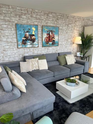 ロンドンにある62 Sqm High Rise Apartment Canary Wharfのリビングルーム(青いソファ、絵画付)