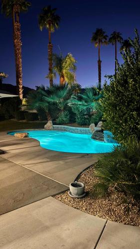 a swimming pool in a yard with palm trees at Palm Breezes in Rancho Mirage