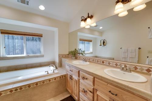 La salle de bains est pourvue de 2 lavabos, d'une baignoire et d'un grand miroir. dans l'établissement Near Donner Lake and Skiing Soda Springs Cabin!, à Soda Springs