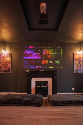a room with a fireplace and a large screen at CinémaRoom Béziers in Béziers
