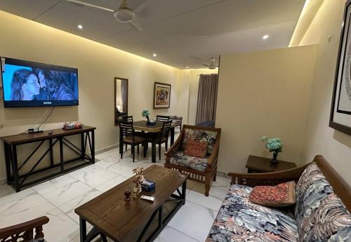 a living room with a couch and a table at Luxury cozy studio apartment with balcony in Lahore