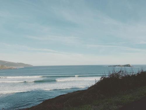 a beach with some waves in the ocean at LAIDA BEACH by Urdaibai Experience in Ibarrangelu