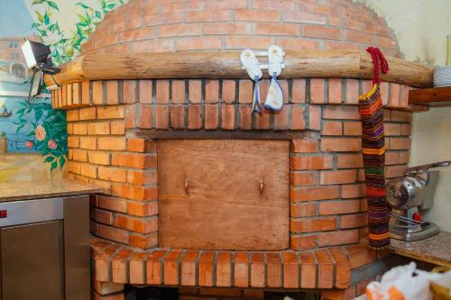 a brick fireplace with a wooden door on it at Mini Hotel Venezia in Atyrau