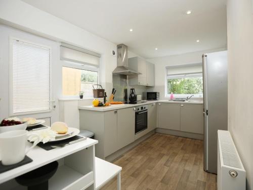 a kitchen with white cabinets and a counter top at Spacious 4 Bedroom House - Sleeps 8 Guests, Contractors, Groups, Families, Business, Leisure & Relocation Stays Welcome, 13 Minutes From City Centre, Fast Wi-Fi, Smart TV In Lounge & FREE Parking, Long Stays And Short Stays Welcome in Bristol