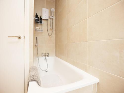 a bathroom with a shower and a tub and a sink at Spacious 4 Bedroom House - Sleeps 8 Guests, Contractors, Groups, Families, Business, Leisure & Relocation Stays Welcome, 13 Minutes From City Centre, Fast Wi-Fi, Smart TV In Lounge & FREE Parking, Long Stays And Short Stays Welcome in Bristol