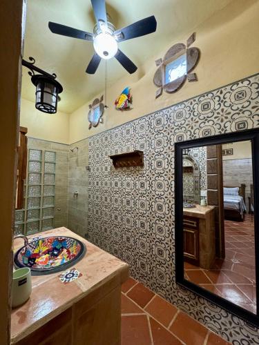 a bathroom with a mirror and a sink and a ceiling fan at Calendario Vacio in Loreto