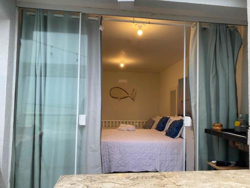 a bedroom with a bed and a glass wall at Pousada dos Sonhos Costa Azul in Rio das Ostras