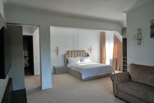 un dormitorio con una cama y un sofá en Infinity Villa, en Predeal