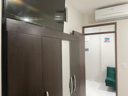 ein Badezimmer mit einer Holztür und einem grünen Stuhl in der Unterkunft Bello y Céntrico Zona Turística Full Equipado in Santa Cruz de la Sierra