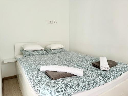 a white bedroom with a bed with towels on it at DowntownKate in Debrecen