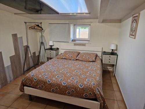 a bedroom with a bed and two night stands and a window at Gîte Kerlosvézan, à la campagne, proche mer in Lampaul-Ploudalmézeau