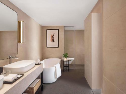 a bathroom with a white tub and a sink at Novotel Mumbai International Airport in Mumbai