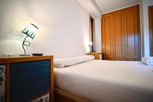 a bedroom with a bed with a television and a lamp at Escapada de esquí I Cerca de Grandvalira con Parking in Soldeu
