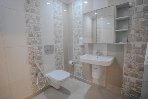 ein weißes Badezimmer mit Toilette und Waschbecken in der Unterkunft Mabaat-White Pearl Compound 600 C Villa 26 in Dschidda