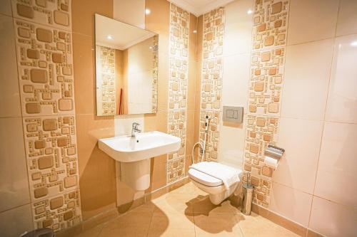 a bathroom with a white toilet and a sink at Mabaat-White Pearl Compound 600 C Villa 24 in Jeddah