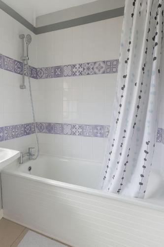 a white bath tub with a shower curtain in a bathroom at Cavan Crescent in Broadstone
