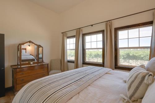 a bedroom with a bed and a mirror and windows at Charming Lodi Retreat Walk to Local Wineries in Lodi