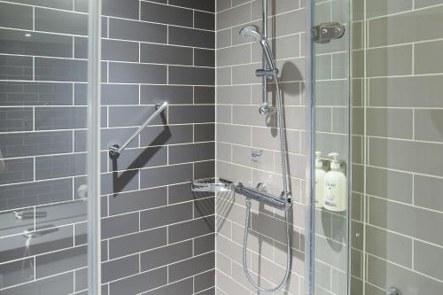 a bathroom with a shower with blue tiles at Holiday Inn Express - Birmingham - City Centre by IHG in Birmingham