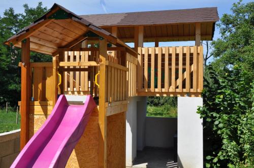 a wooden play structure with a slide at Penzión Veperec in Hokovce