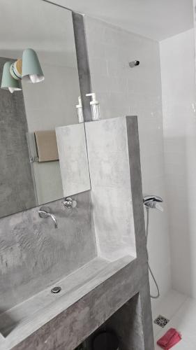a bathroom with a sink and a mirror at Moradia Sisudo in Colares
