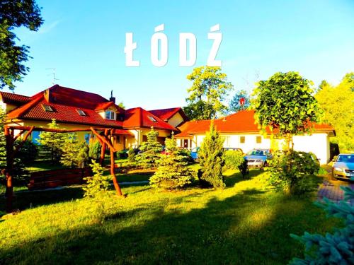 een huis met rode daken en een tuin bij ŁÓDZKI DOM TURYSTYCZNY ŁÓDŹ-Helenówek,Pokoje z łazienkami,F-VAT,Parking gratis tylko auta osobowe in Łódź